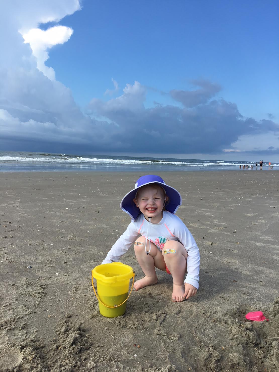 kid playing with beach bucket at holden beach
