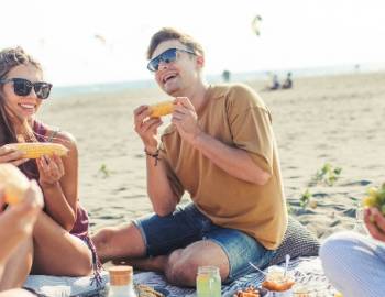 happy-group-of-people-eating-on-beach