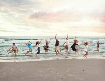 family jumping at holden beach