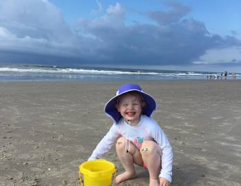 kid playing with beach bucket at holden beach