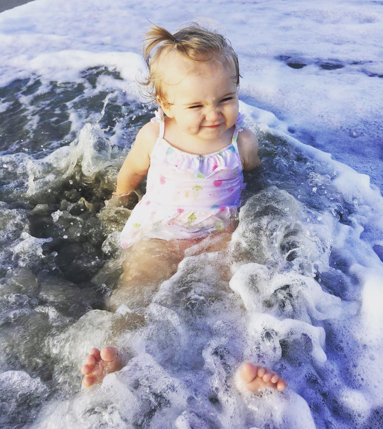 toddler playing in water at holden beach