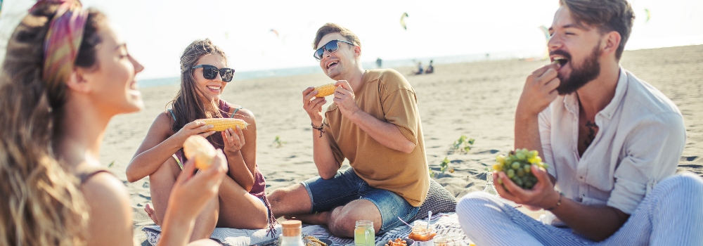 happy-group-of-people-eating-on-beach