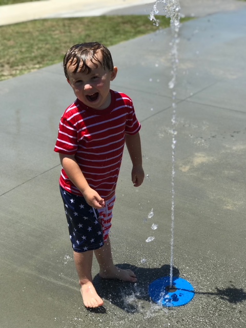 kid playing in holden beach splash pad